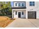 Modern two-story home with a black garage door and a concrete driveway at 331 Roxboro St, Haw River, NC 27258