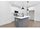 Modern kitchen with white cabinets, gray island, and black pendant lighting at 331 Roxboro St, Haw River, NC 27258