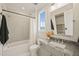 Bathroom featuring a gray vanity, a tub with shower, and a bright, natural light window at 1621 Legacy Ridge Ln, Wake Forest, NC 27587