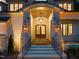 Inviting front porch featuring stone columns, an arched entry, stylish lighting, and a warm, welcoming ambiance at 1621 Legacy Ridge Ln, Wake Forest, NC 27587