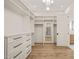 Large walk-in closet with custom cabinets, shelves, drawers, and mirrored dressing area at 1621 Legacy Ridge Ln, Wake Forest, NC 27587