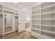 Well organized walk-in closet featuring built-in shelving and a view into the bathroom at 1621 Legacy Ridge Ln, Wake Forest, NC 27587