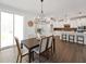 Bright dining area featuring a modern light fixture, wood floors, and an open floor plan leading to the kitchen at 1505 Patchings Ln, Knightdale, NC 27545