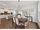 Elegant dining room featuring a chandelier, wood floors, and adjacent kitchen and living area at 1505 Patchings Ln, Knightdale, NC 27545