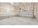 Unfinished two-car garage with concrete flooring and overhead storage at 1505 Patchings Ln, Knightdale, NC 27545