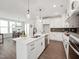 Open-concept kitchen with white cabinets, a large island, and stainless steel appliances at 1505 Patchings Ln, Knightdale, NC 27545