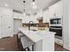 Bright kitchen with white cabinets, stainless steel appliances, and an island with bar stool seating at 1505 Patchings Ln, Knightdale, NC 27545