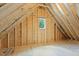 Unfinished attic space with exposed wooden beams and a window providing natural light at 3691 Graham Sherron Rd, Wake Forest, NC 27587