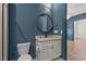 Blue bathroom featuring toilet, sink with vanity, and a round mirror at 3691 Graham Sherron Rd, Wake Forest, NC 27587