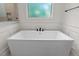 Modern bathroom featuring a large soaking tub with stylish fixtures and ample natural light at 3691 Graham Sherron Rd, Wake Forest, NC 27587