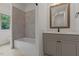Bathroom featuring white tub and vanity with gray cabinets at 3691 Graham Sherron Rd, Wake Forest, NC 27587
