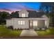 Exterior of home at dusk with neutral siding, screened porch, and manicured lawn at 3691 Graham Sherron Rd, Wake Forest, NC 27587