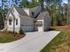 Exterior home view with large garage and inviting driveway and sidewalk at 3691 Graham Sherron Rd, Wake Forest, NC 27587