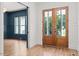 Grand foyer with hardwood floors, glass paneled wood door, wainscotting, and paneled walls at 3691 Graham Sherron Rd, Wake Forest, NC 27587