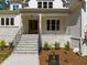 Inviting front entrance with stone stairs, manicured landscaping, and a charming covered porch at 3691 Graham Sherron Rd, Wake Forest, NC 27587