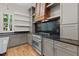 Modern kitchen with grey cabinets, stainless steel appliances, and stunning hardwood floors and a designer range hood at 3691 Graham Sherron Rd, Wake Forest, NC 27587