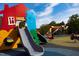 Colorful playground equipment set against a bright blue sky with a modern rubber-coated surface at 618 Velma Hopkins Ln, Raleigh, NC 27603