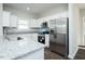 Bright kitchen with white cabinets, stainless steel appliances, and sleek granite countertops at 105 Ambergate Ct, Rocky Mount, NC 27804