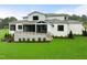 The back exterior shows the porch and white brick exterior against a lush green lawn at 1701 Legacy Ridge Ln, Wake Forest, NC 27587