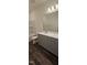 Modern bathroom featuring a single sink vanity, bath tub, and wood-look flooring at 191 Robert Howe Dr, Fuquay Varina, NC 27526