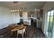 Open-concept kitchen features an island, stainless steel appliances, and an adjacent dining area with modern light fixture at 191 Robert Howe Dr, Fuquay Varina, NC 27526