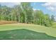 Spacious backyard with lush green grass, mature trees, and a wooden fence at 401 Winding Creek Dr, Lillington, NC 27546