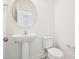 Elegant powder room featuring a pedestal sink and oval mirror in a minimalist design at 401 Winding Creek Dr, Lillington, NC 27546