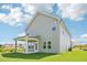 Back exterior view highlighting the light gray siding, covered patio, and green lawn at 401 Winding Creek Dr, Lillington, NC 27546