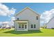 Exterior view of the rear of the house with light gray siding and a covered patio at 401 Winding Creek Dr, Lillington, NC 27546