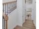 Bright foyer features hardwood floors, staircase with decorative iron spindles, and view of kitchen at 401 Winding Creek Dr, Lillington, NC 27546