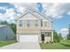 Two-story brick home boasts an attached two-car garage, manicured lawn, and inviting front porch at 401 Winding Creek Dr, Lillington, NC 27546