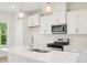 Bright, modern kitchen featuring stainless steel appliances, white cabinetry, and a kitchen island at 401 Winding Creek Dr, Lillington, NC 27546