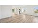 Spacious living room area with modern light wood floors, natural light, and a view into the kitchen at 401 Winding Creek Dr, Lillington, NC 27546