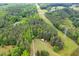 Sprawling wooded acreage features a rustic barn and utility lines in a pastoral setting at 2723 New Sharon Church Rd, Hillsborough, NC 27278