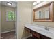 The bathroom features a wood-framed mirror, white countertops, dark wood cabinets and a window at 2723 New Sharon Church Rd, Hillsborough, NC 27278