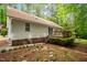 Backyard view of a house with a deck, landscaped yard, and mature trees at 2723 New Sharon Church Rd, Hillsborough, NC 27278