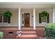 Inviting front porch featuring brick steps, white columns, and a charming wooden front door at 2723 New Sharon Church Rd, Hillsborough, NC 27278