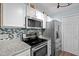 Well-equipped kitchen with stainless steel appliances, granite countertops, and blue decorative backsplash at 2723 New Sharon Church Rd, Hillsborough, NC 27278