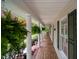 Relaxing side porch with white columns, ferns, and verdant landscaping at 2723 New Sharon Church Rd, Hillsborough, NC 27278