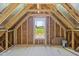 Unfinished attic space showing the construction and window view at 30 Diamond Creek Dr, Zebulon, NC 27597