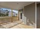 Covered back porch with wooden floor and railing offers a view of the backyard at 30 Diamond Creek Dr, Zebulon, NC 27597