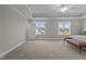 Bright main bedroom featuring neutral walls, carpet, tray ceiling with a ceiling fan, and large windows at 30 Diamond Creek Dr, Zebulon, NC 27597