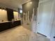Spacious bathroom with walk-in shower, double vanities, and patterned tile flooring at 4905 Hidden Pasture Way, Zebulon, NC 27597