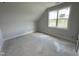 Bright bedroom featuring a large window offering ample natural light into the unfinished room with bare floors at 4905 Hidden Pasture Way, Zebulon, NC 27597
