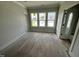 Bright bedroom showcasing hardwood floors and large windows with natural light and neighborhood views at 4905 Hidden Pasture Way, Zebulon, NC 27597