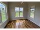 Bedroom with natural light showing hardwood floors and scenic views through large windows at 4905 Hidden Pasture Way, Zebulon, NC 27597