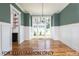 Dining room with natural light, wood floor, and wainscoting at 4905 Hidden Pasture Way, Zebulon, NC 27597