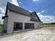 View of the back of a two-story home with an attached three-car garage at 4905 Hidden Pasture Way, Zebulon, NC 27597