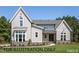 A beautiful, modern home featuring a combination of gray siding, brick accents, and a well-manicured lawn at 4905 Hidden Pasture Way, Zebulon, NC 27597