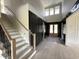 A two-story foyer with a staircase, black paneled walls, and light wood floors at 4905 Hidden Pasture Way, Zebulon, NC 27597